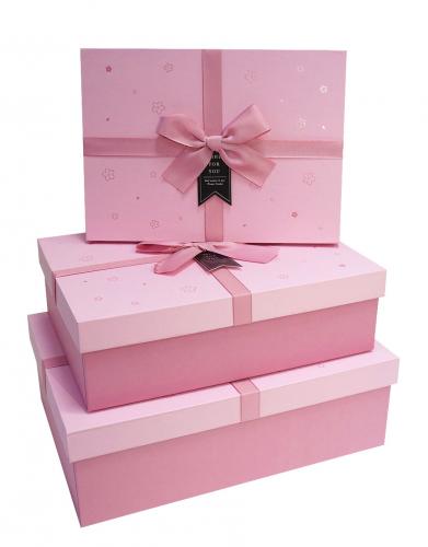 Набор из трёх прямоугольных подарочных коробок розового цвета с бантом из ленты, отделка софт-тач бумагой с цветочками, размер 29*21*9,5 см.
