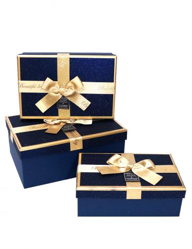 Набор из трёх синих прямоугольных подарочных коробок с золотистыми краями и бантом из ленты, отделка фактурной блестящей бумагой, размер 22*16*9,5 см.